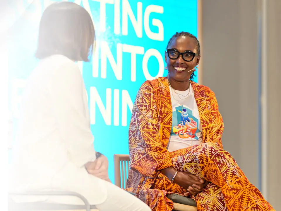 Dr. Égo Obi smiling, seated on stage during a panel conversation